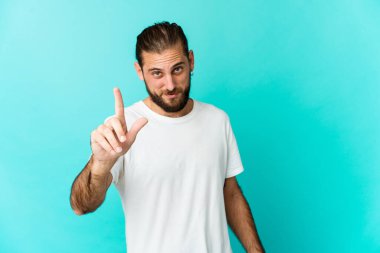 Uzun saçlı genç adam parmaklarıyla bir numarayı gösteriyor..