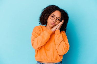 Genç Afro-Amerikan melez kadın kendini izole etmiş esniyor ve ağzını eliyle kapatan yorgun bir jest yapıyor..