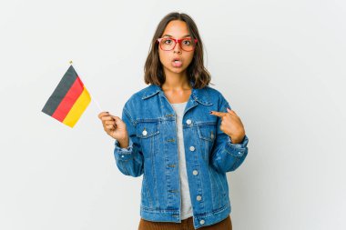 Beyaz arka planda izole edilmiş Alman bayrağını tutan genç Latin kadın parmakları aşağıda, olumlu bir his..