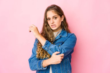 Genç beyaz kadın dirsek masajı yapıyor, kötü bir hareketin ardından acı çekiyor..