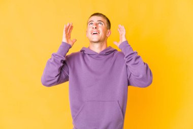 Beyaz tenli yakışıklı adam elini göğsüne koyup kahkahalar atıyor..