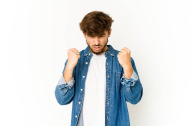 Beyaz arka planda genç bir Arap, kameraya yumruğunu gösteriyor, agresif yüz ifadesi..