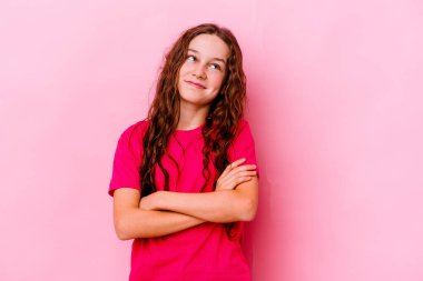 Pembe arka planda izole edilmiş küçük beyaz kız hedeflere ve amaçlara ulaşmayı hayal ediyor.