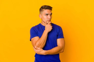 Genç, yakışıklı, beyaz tenli, soyutlanmış, kuşkucu bir ifadeyle yana bakan bir adam..