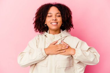 Genç Afro-Amerikan melez kadın kahkahalarla gülüyor ellerini kalbe atıyor, mutluluk kavramını koruyor..