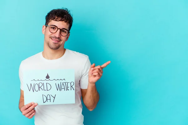 Jonge Blanke Man Viert Wereldwaterdag Geïsoleerd Een Blauwe Achtergrond Glimlachend — Stockfoto