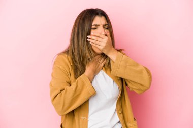 Pembe arka planda izole edilmiş genç Hintli kadın virüs veya enfeksiyon yüzünden boğaz ağrısı çekiyor..