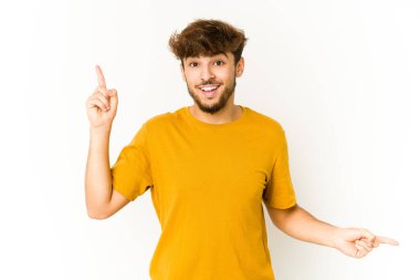 Beyaz arka plandaki genç Arap adam farklı kopya alanlarını gösteriyor, birini seçiyor, parmaklarıyla gösteriyor.