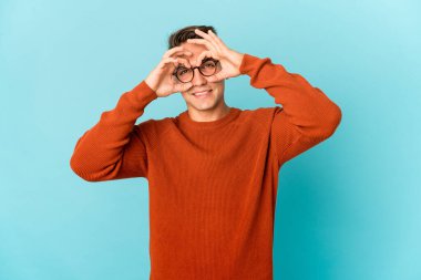 Genç, beyaz, yakışıklı bir adam izole edilmiş, gözlerinde işaret var.