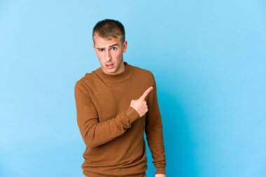 Kafkasyalı yakışıklı genç adam yan tarafı işaret ediyor.