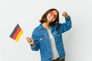 Beyaz arka planda izole edilmiş Alman bayrağı tutan genç Latin bir kadın. Kollarını uzatıyor, rahat bir konumda..