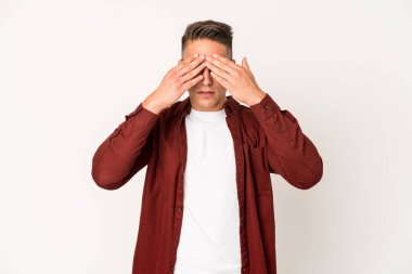 Genç, beyaz, yakışıklı bir adam izole edilmiş. Gözleri elleriyle kapatmaktan korkuyor..