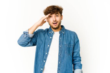 Beyaz arka plandaki genç Arap yüksek sesle bağırıyor, gözleri açık ve elleri gergin tutuyor..