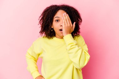 Genç Afro-Amerikan melez kadın izole edilmiş. Yüzünün yarısını avuç içiyle kaplayarak eğleniyor..