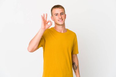 Genç, beyaz, yakışıklı, neşeli ve kendinden emin bir adam iyi bir jest yapıyor..