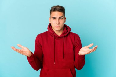 Kafkasyalı yakışıklı bir adam izole edilmiş, kafası karışmış ve omuz silkiyor..