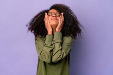 Genç Afro-Amerikalı kıvırcık kadın, mor arka planda yalnız, sızlanıyor ve ağlıyordu..