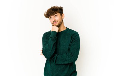 Beyaz arka plandaki genç Arap adam rahatlamış fotokopi alanına bakan bir şey düşünüyor..