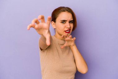 Genç Arap melez kadın pençelerini kedi taklidi yaparken gösteriyor, agresif bir hareket..