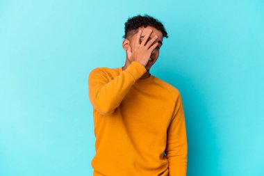 Genç Afro-Amerikalı kıvırcık adam kameraya parmaklarıyla göz kırpıyor, yüzünü kapatmaktan utanıyor..