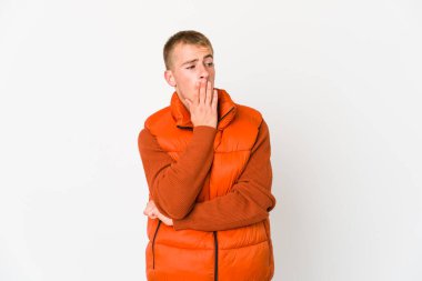 Beyaz tenli yakışıklı adam esniyor. Ağzı eliyle kapatan yorgun bir jest yapıyor..