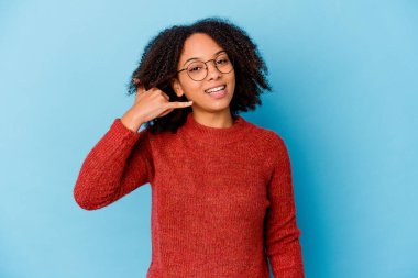 Genç Afro-Amerikan melez kadın izole edilmiş, parmaklarıyla bir cep telefonu hareketi gösteriyor..