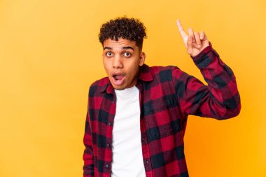 Genç Afro-Amerikan kıvırcık adamı, mor üzerine izole edilmiş. Harika bir fikri var, yaratıcılık kavramı..