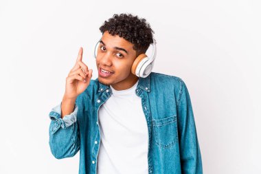 Genç Afro-Amerikan kıvırcık adamı kulaklıkla müzik dinlerken bir fikri, ilham konsepti var..