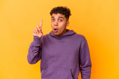 Genç Afro-Amerikan kıvırcık adamı, mor üzerine izole edilmiş. Harika bir fikri var, yaratıcılık kavramı..