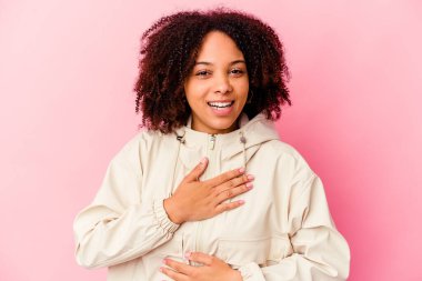 Genç Afro-Amerikan melez kadın mutlu mesut gülüyor ve ellerini karnına koymaktan zevk alıyor..