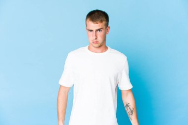 Beyaz tenli yakışıklı adam yanakları siliyor, yorgun bir ifade takınıyor. Yüz ifadesi kavramı.