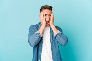 Genç, beyaz, yakışıklı bir adam kulaklarını kapatıyor ve yüksek sesli sesler duymamaya çalışıyor..