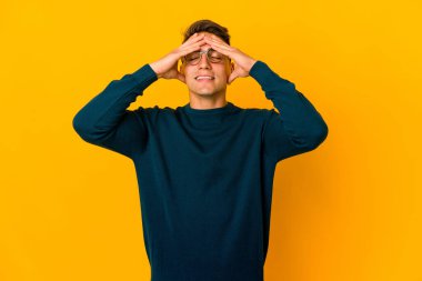 Genç, yakışıklı, beyaz tenli, soyutlanmış, gülen, ellerini başının üstünde tutan bir adam. Mutluluk kavramı.