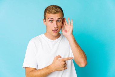 Bir dedikoduyu dinlemeye çalışan beyaz, yakışıklı genç bir adam..