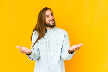 Uzun saçlı genç adam hoş bir yüz ifadesi sergiliyor..