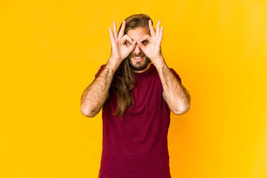 Uzun saçlı genç adam iyi görünüyor. Gözlerinde işaret var.