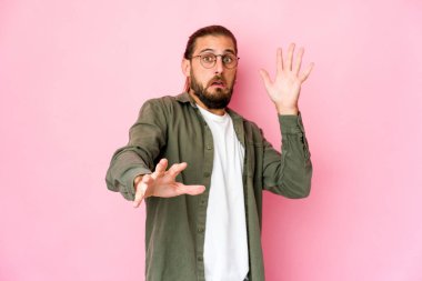 Uzun saçlı genç adam yakın bir tehlike yüzünden şoka girmiş gibi görünüyor.