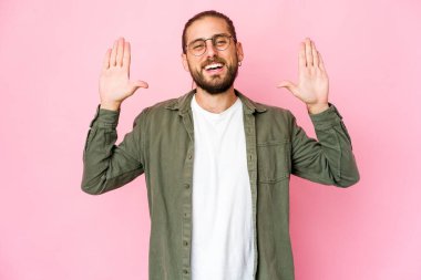 Uzun saçlı genç adam on numarayı elleriyle gösteriyor..