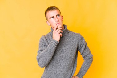 Kafkasyalı yakışıklı bir genç şüpheli ve şüpheci bir ifadeyle yana bakıyor..