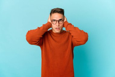 Genç, beyaz, yakışıklı bir adam kulaklarını kapatıyor ve yüksek sesli sesler duymamaya çalışıyor..