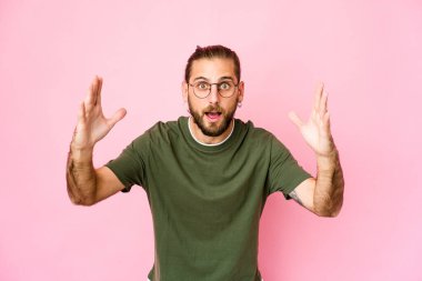 Uzun saçlı genç adam hoş bir sürpriz bekliyor, heyecanlı ve el kaldırıyor..