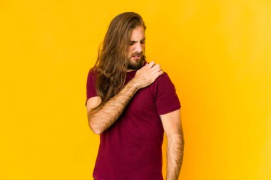 Uzun saçlı, omuz ağrısı çeken genç bir adam..