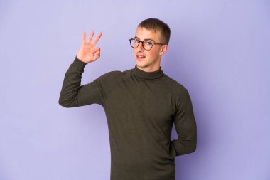 Beyaz tenli yakışıklı bir adam göz kırptı ve elleriyle iyi bir jest yaptı..