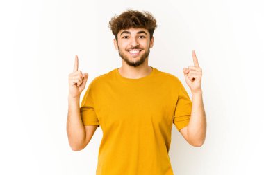 Beyaz arka plandaki genç Arap, iki ön parmağı da boş bir alan gösterirken....