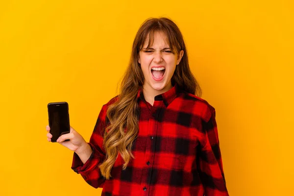 Junge Kaukasische Frau Hält Telefon Isoliert Auf Gelbem Hintergrund Schreit — Stockfoto