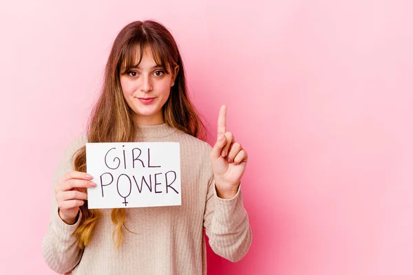 年轻的高加索女人拿着一个粉色背景的女孩权力标牌 带着第一个手指 — 图库照片