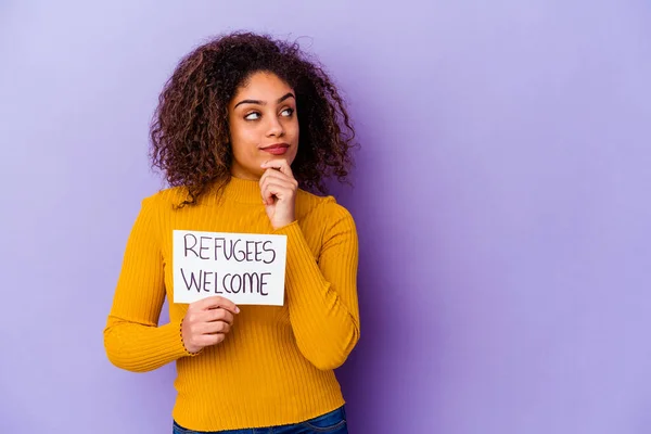 難民を抱えている若いアフリカ系アメリカ人女性は 疑わしく懐疑的な表情で横に見える孤立したプラカードを歓迎する — ストック写真