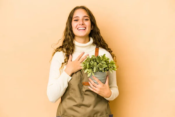Młody Biały Ogrodnik Kobieta Trzyma Roślinę Odizolowany Śmieje Się Głośno — Zdjęcie stockowe