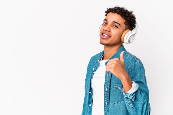 若いアフリカ系アメリカ人の巻き毛の男は ヘッドフォンの笑顔と親指を上げると音楽を聞いて隔離 — ストック写真