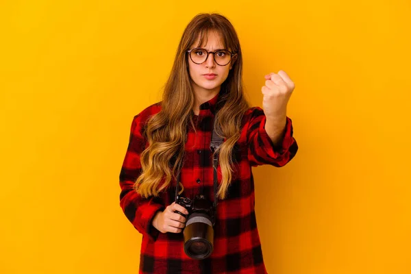 若い写真家の白人女性は カメラに拳を示す黄色の背景に隔離されました 積極的な表情 — ストック写真